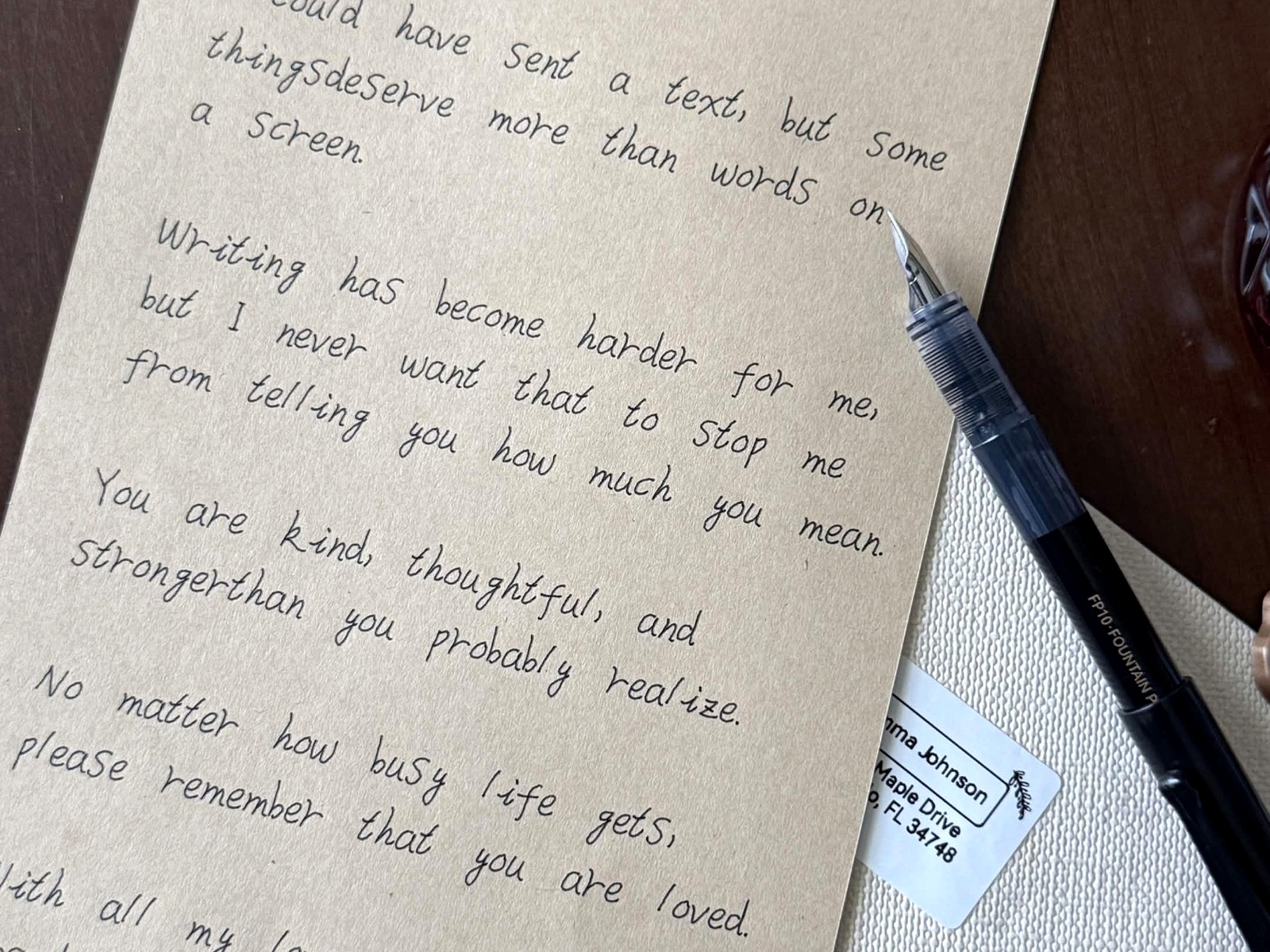 A finished Spoken Letters letter with an envelope and pen on a wooden table
